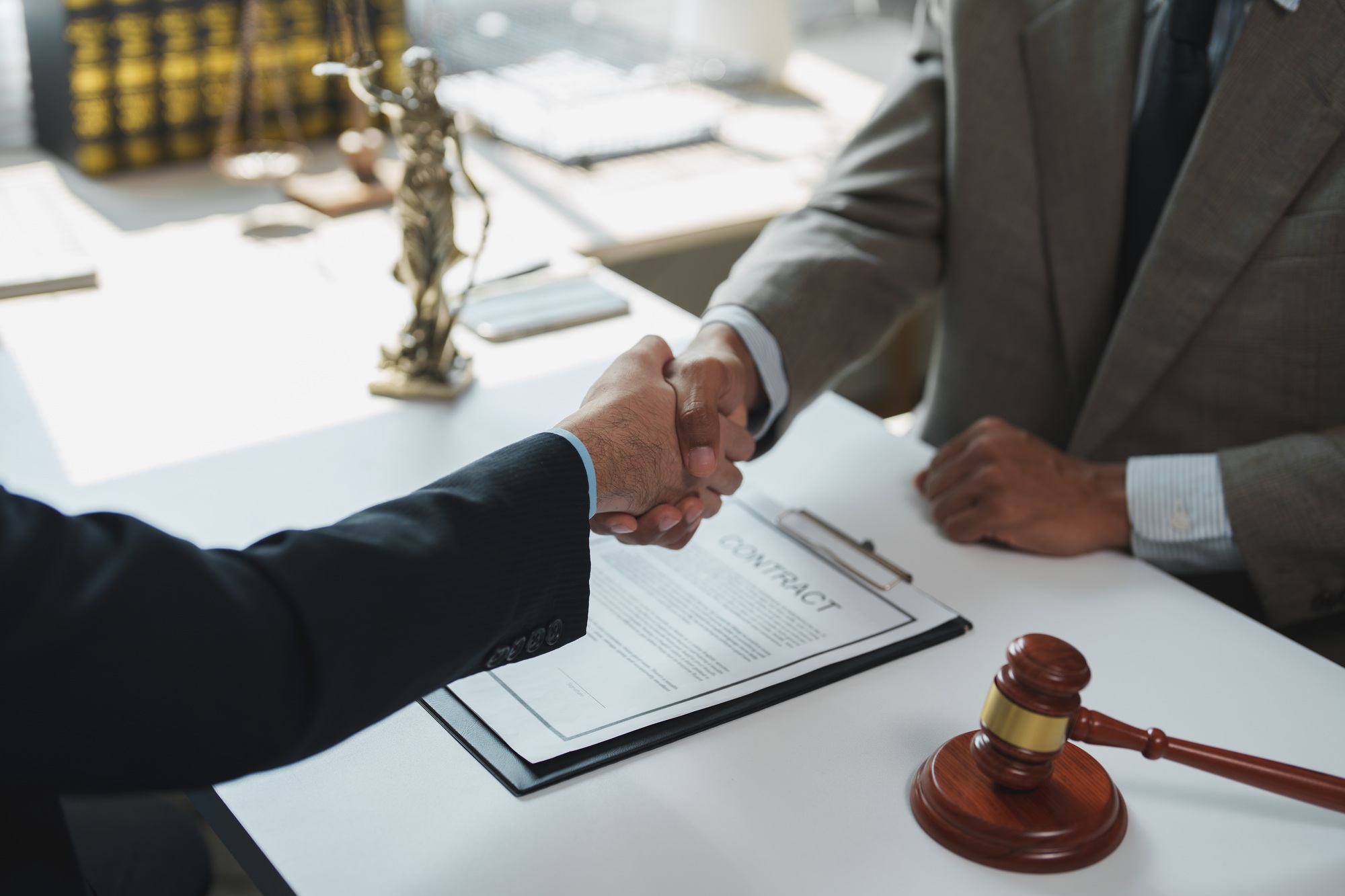 Lawyers shaking hands after signing contract in law office